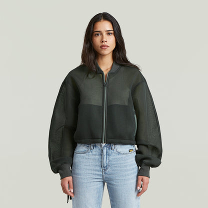 Chaqueta Meshy Binding Loose La Meshy Binding Jacket tiene un fit oversized con largo cropped y cuello alto (stand-up).