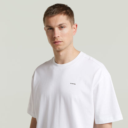 Model wearing relaxed fit graphic tee in white, featuring G-Star logo and relaxed cut for comfortable styling.