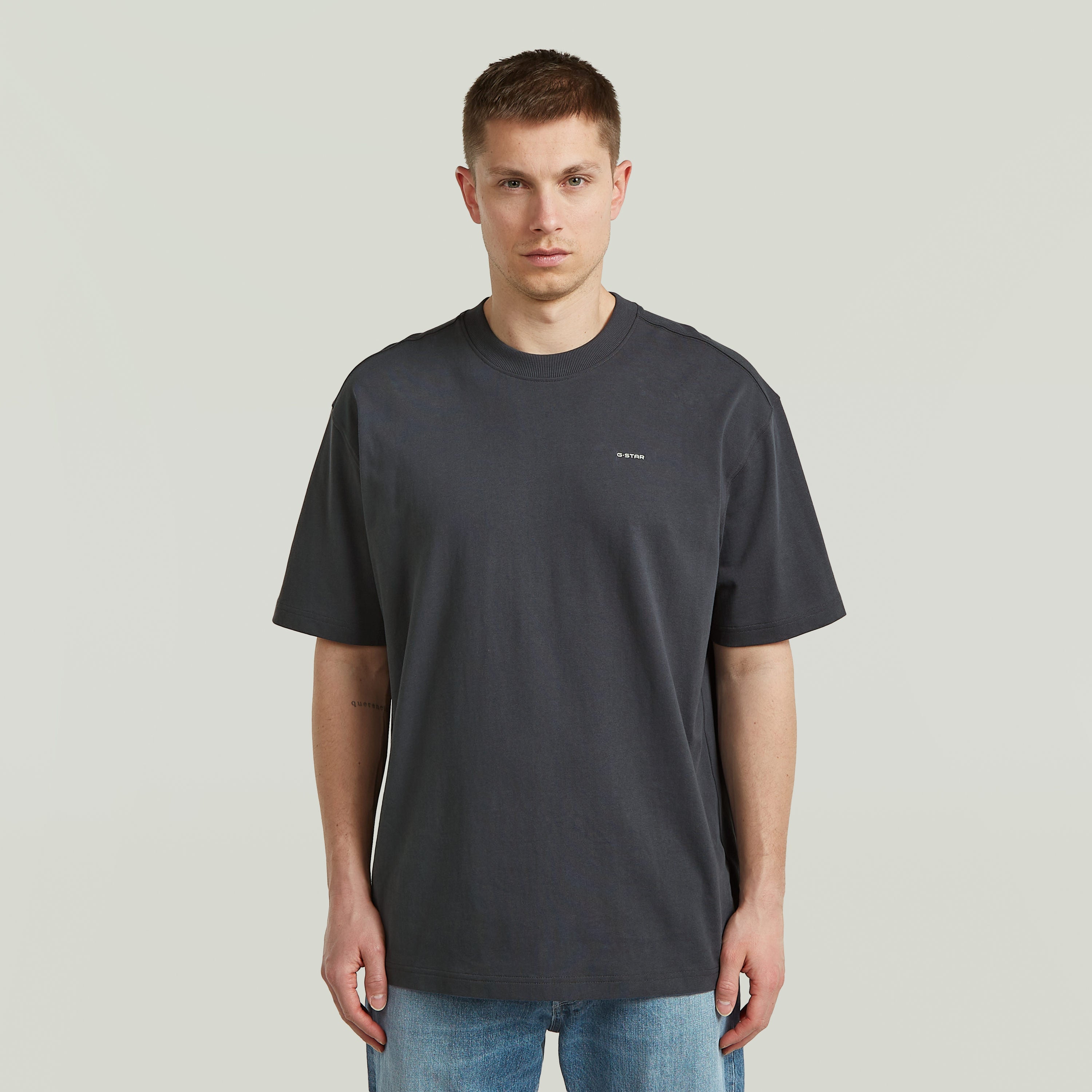 Modelo usando una camiseta Back Graphic Relaxed gris, una relaxed graphic t-shirt de corte relajado y ecológica.