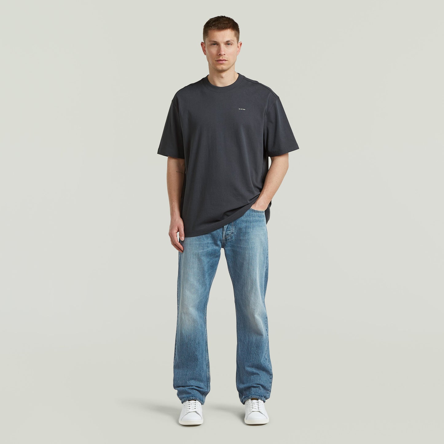 Modelo con camiseta Back Graphic Relaxed, una relaxed graphic t-shirt de color gris y corte moderno.