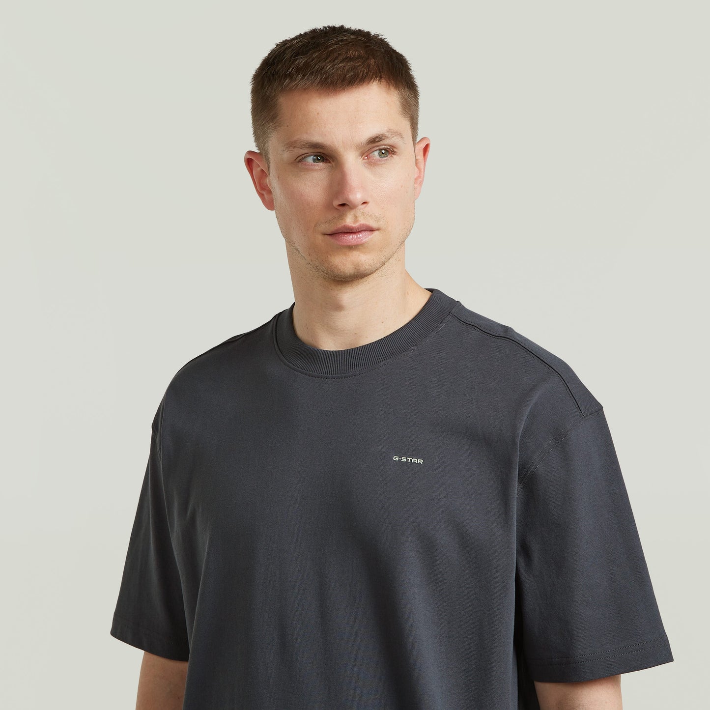 Hombre usando una camiseta Back Graphic Relaxed gris, un modelo de relaxed graphic t-shirt con diseño moderno.
