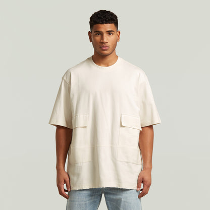 Modelo usando camiseta Utility Fabric Mix en color blanco, con corte suelto y detalles de bolsillos.