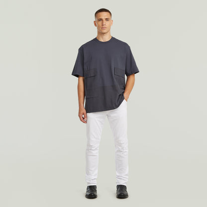 Model wearing a utility fabric mix t-shirt with two front pockets, relaxed fit, in gray color.
