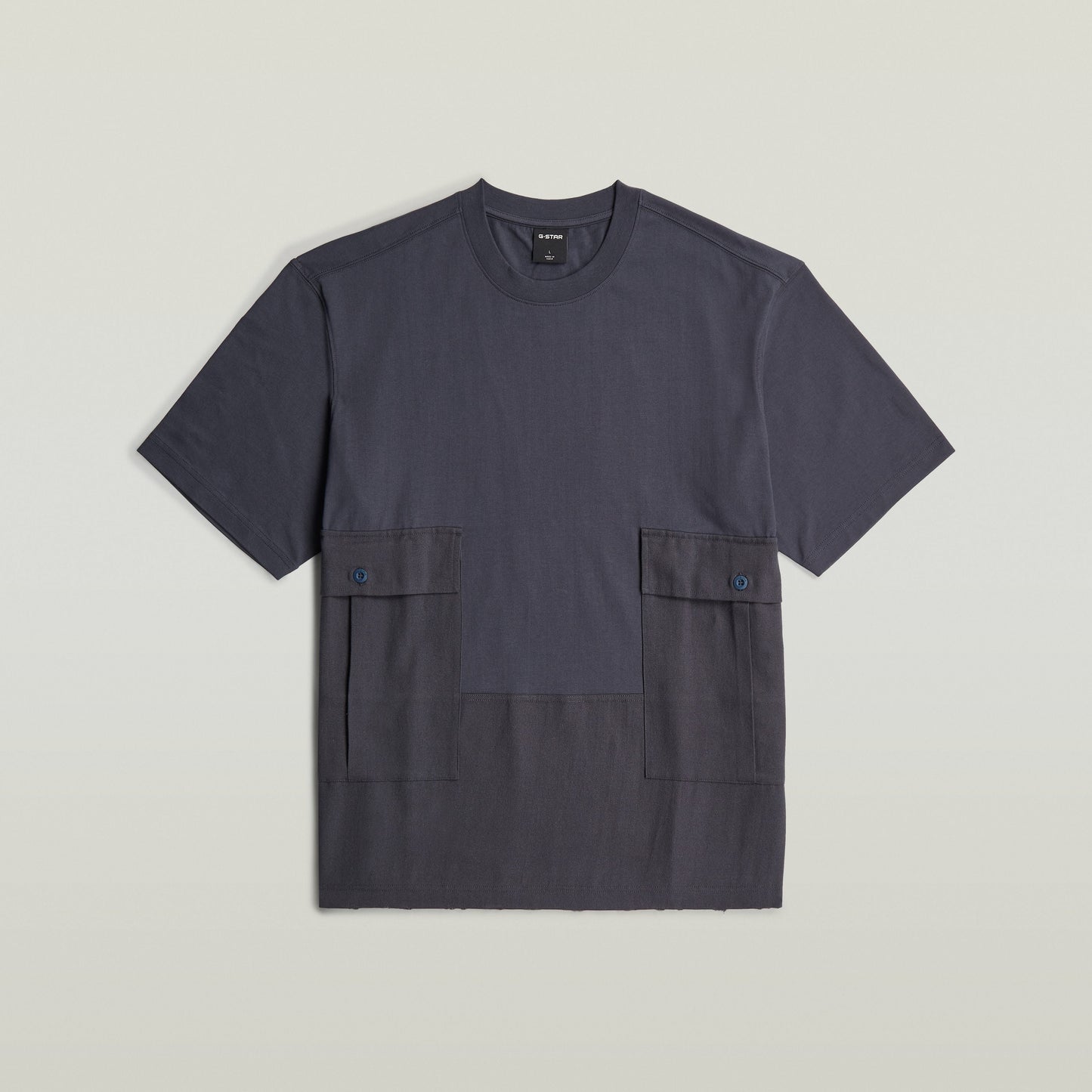 Camiseta Utility Fabric Mix con corte suelto, cuello redondo y dos bolsillos delanteros funcionales.