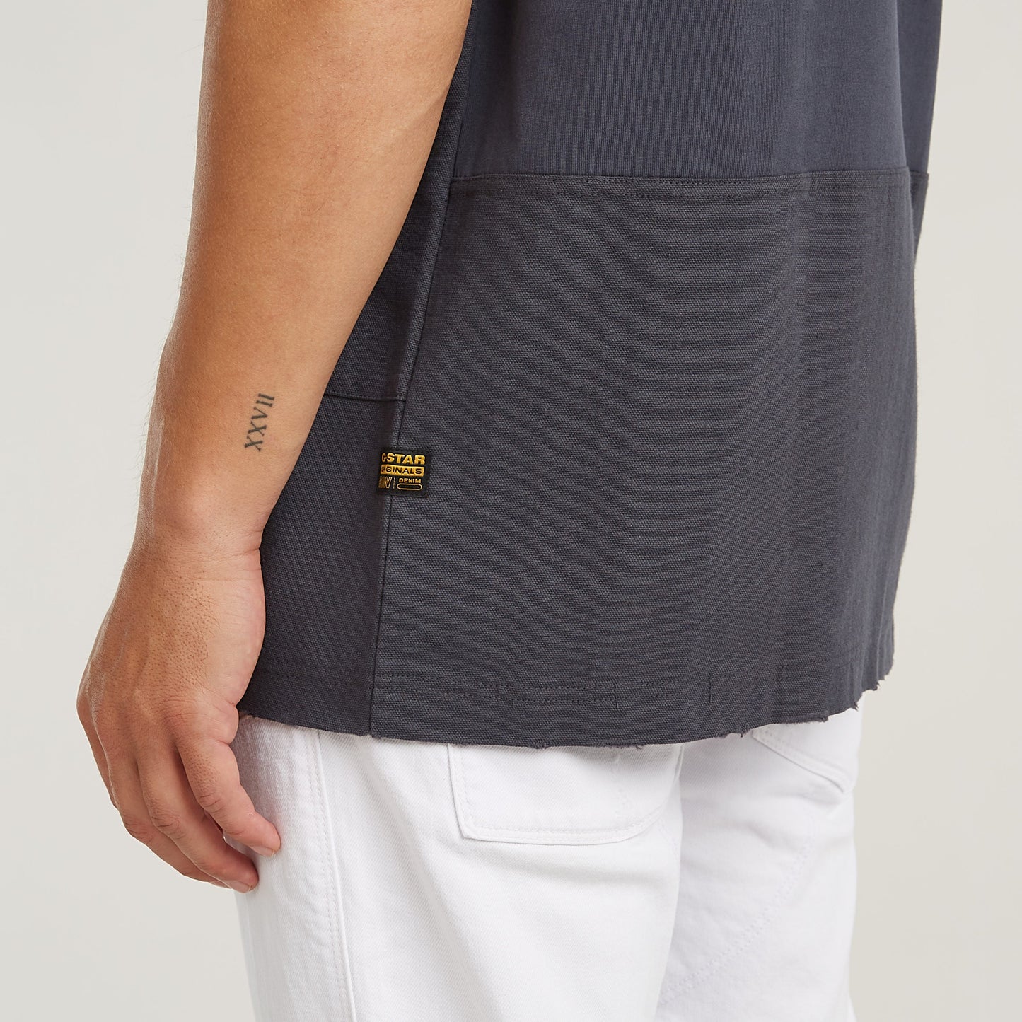 Utility fabric mix t-shirt featuring a loose fit, round neck, and functional front pockets in gray.