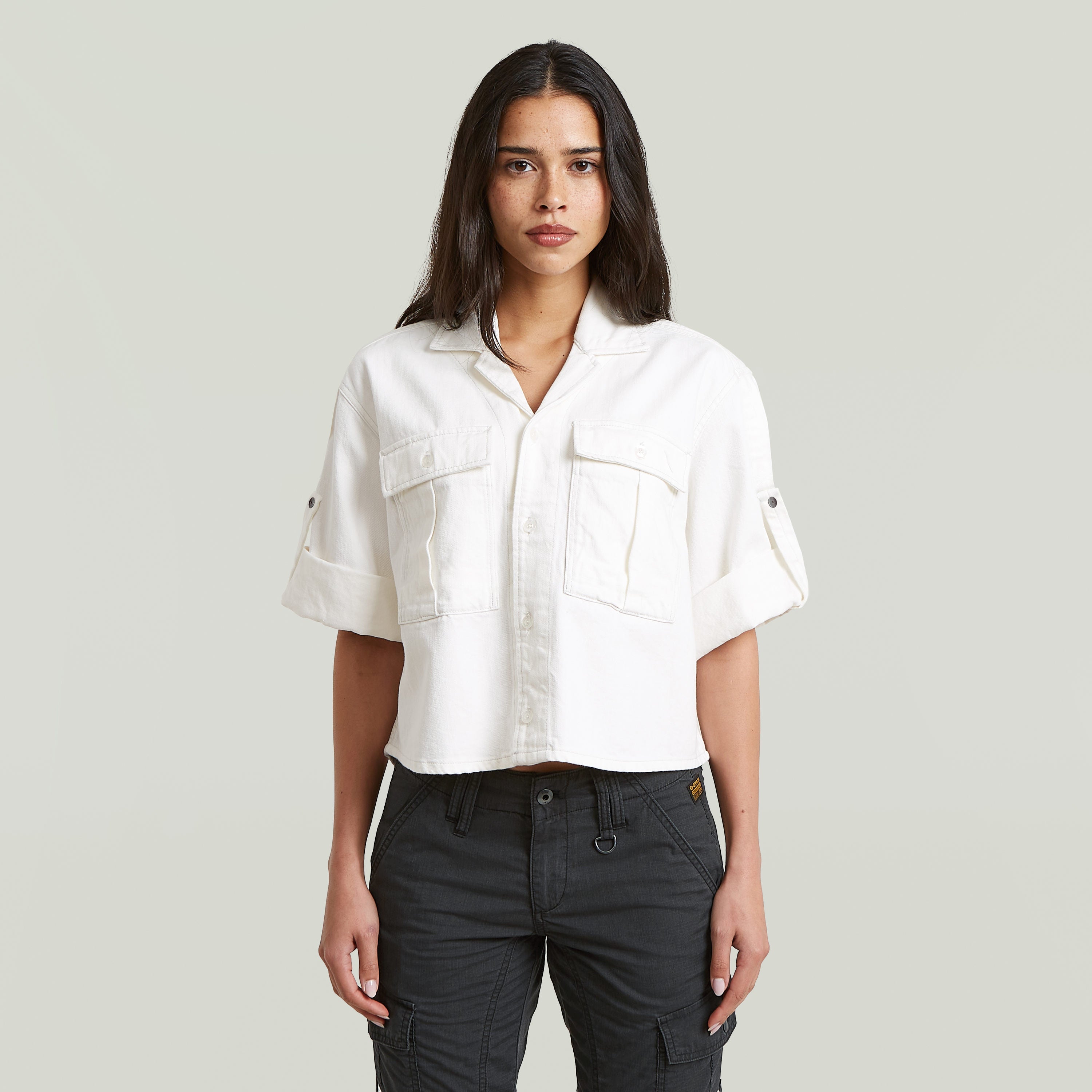 Model wearing a white relaxed fit boxy shirt with short sleeves and a classic collar.