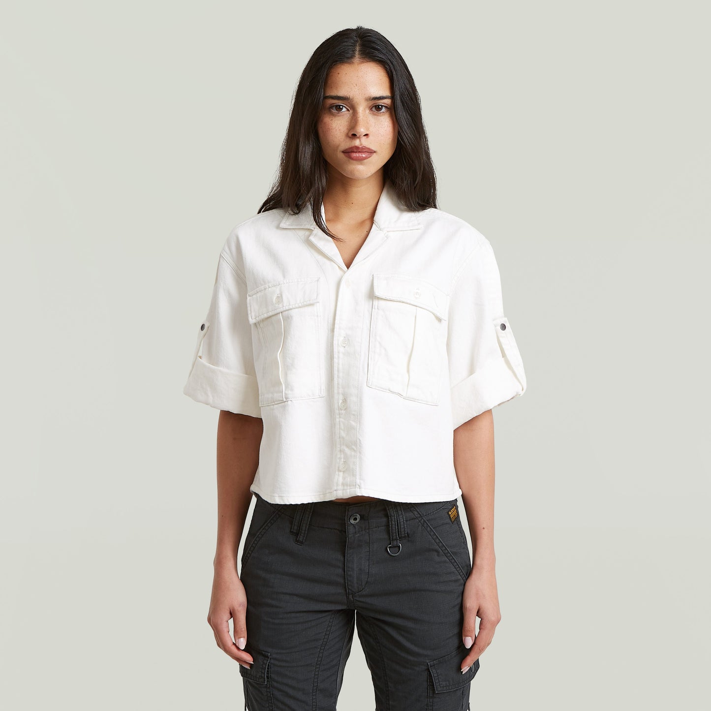 Model wearing a white relaxed fit boxy shirt with short sleeves and a classic collar.