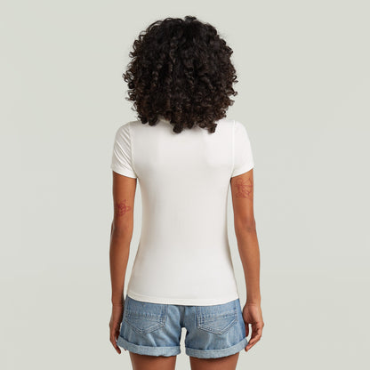 Mujer de espaldas vistiendo camiseta ajustada de modal blanca con cuello redondo y manga corta.