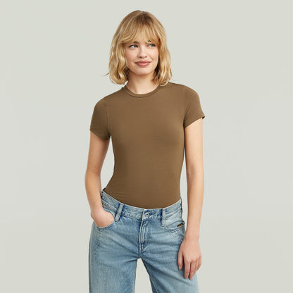 Mujer luciendo una ajustada camiseta de modal marrón con corte elegante y cómodo.