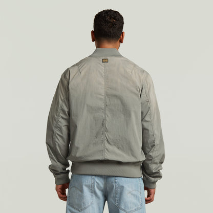 Vista trasera de la cazadora Sunfaded Bomber en color verde, con corte regular y cuello acanalado.