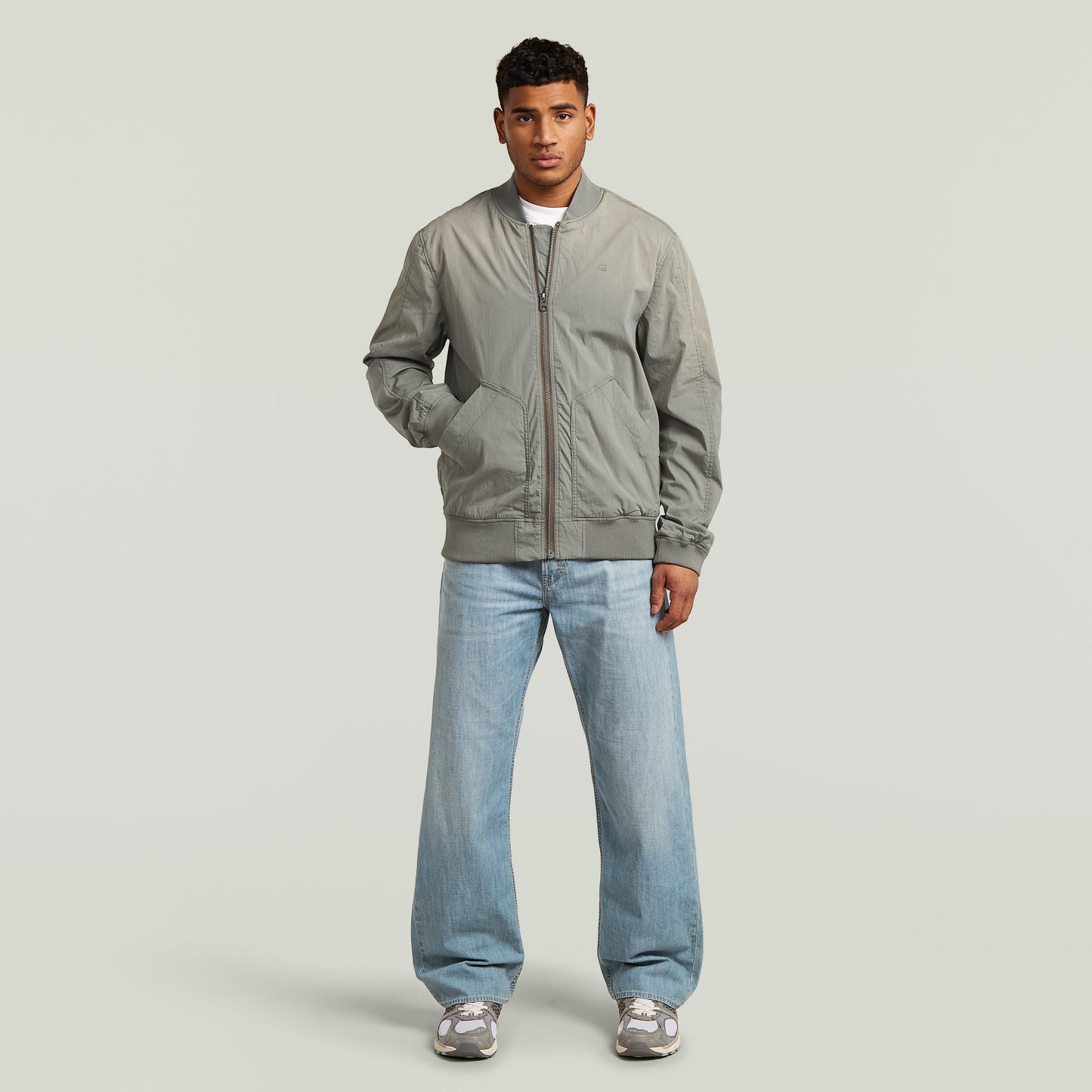 Hombre usando una cazadora Sunfaded Bomber en color verde con corte regular y cierre de cremallera.