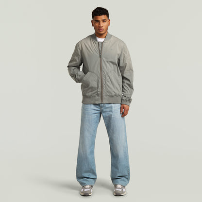 Hombre usando una cazadora Sunfaded Bomber en color verde con corte regular y cierre de cremallera.