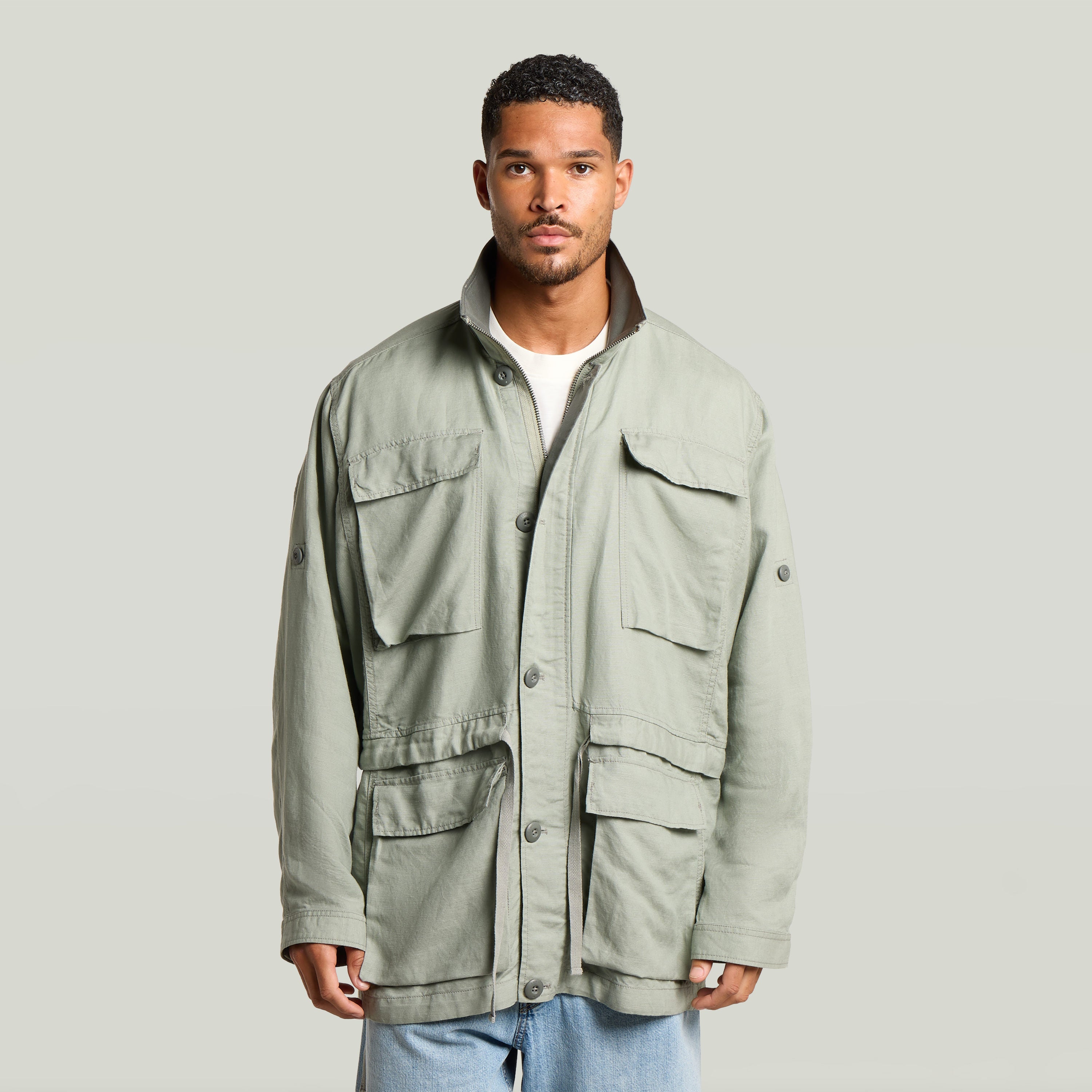Versatile field smock jacket in green, featuring multiple pockets and a structured design, perfect for various occasions.