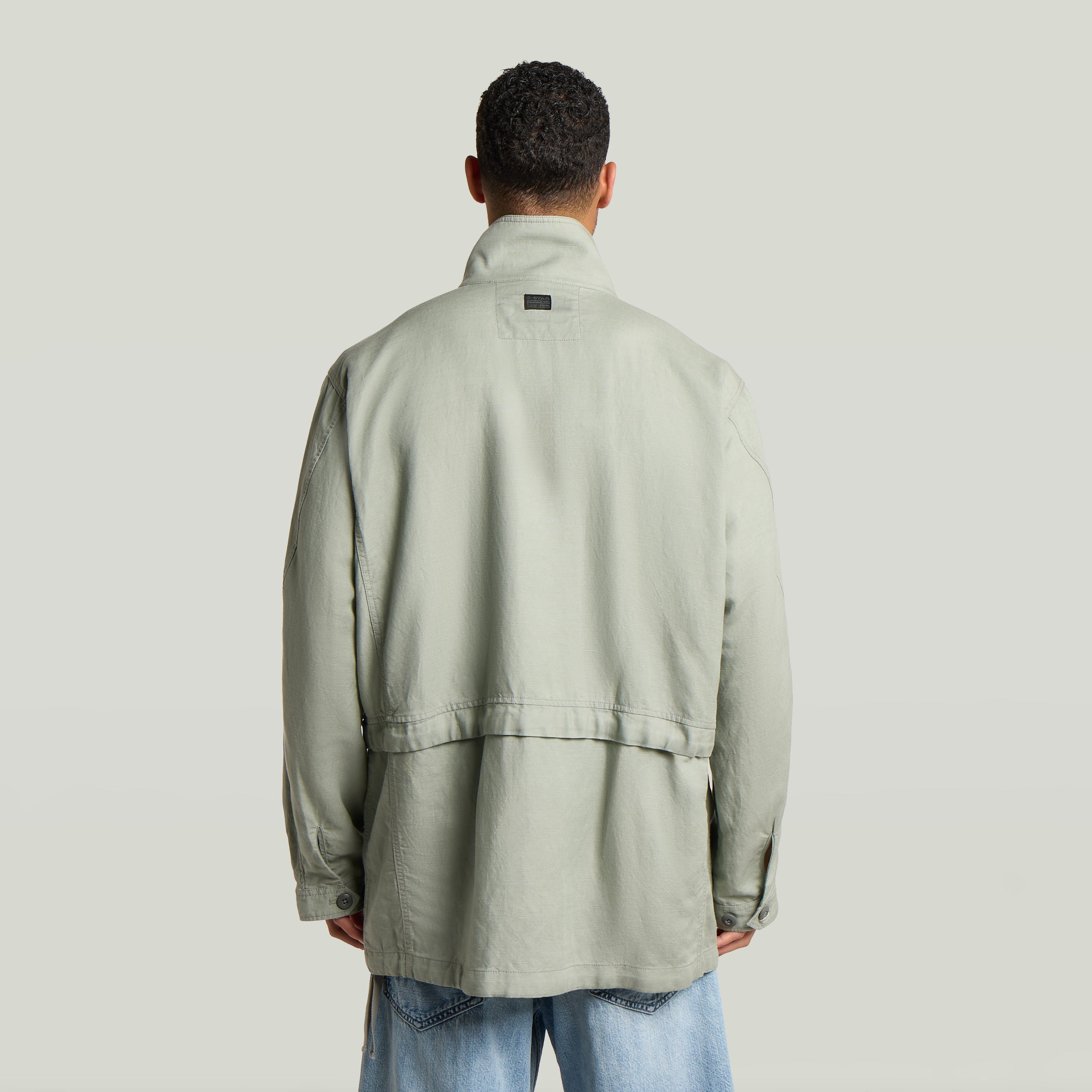 Versatile field smock jacket featuring a relaxed fit and back view in light green color.