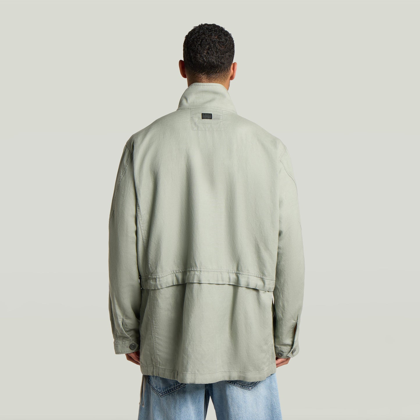 Versatile field smock jacket featuring a relaxed fit and back view in light green color.