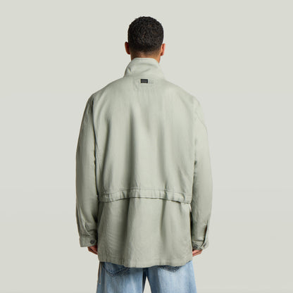 Versatile field smock jacket featuring a relaxed fit and back view in light green color.