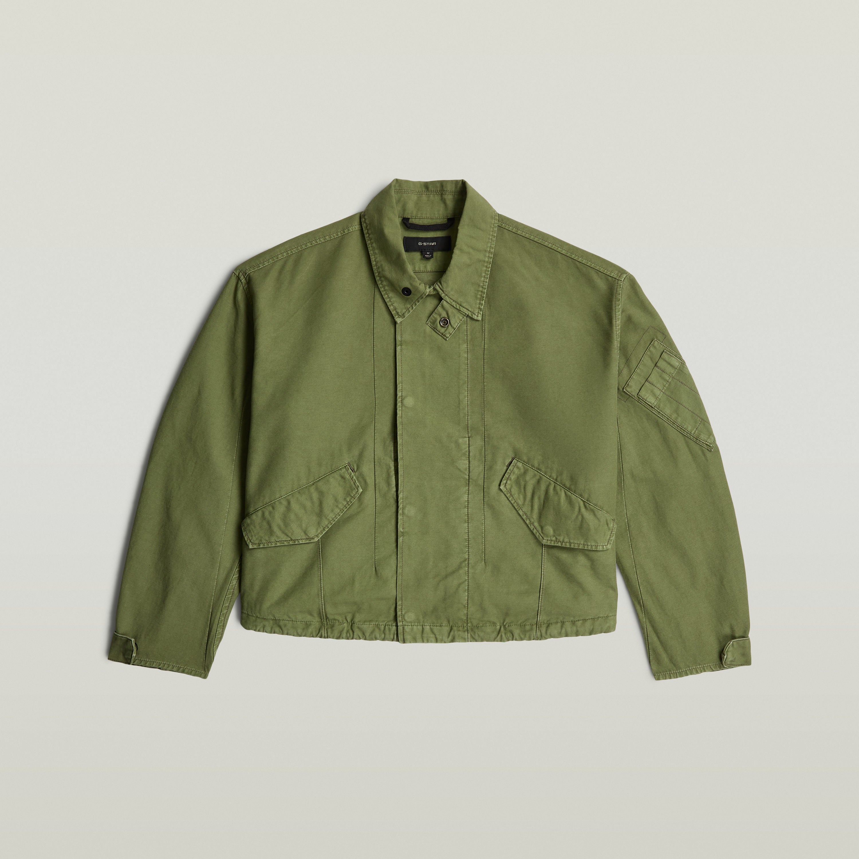 Chaqueta Oversized Cropped en verde con corte corto, cuello de camisa y botones a presión.