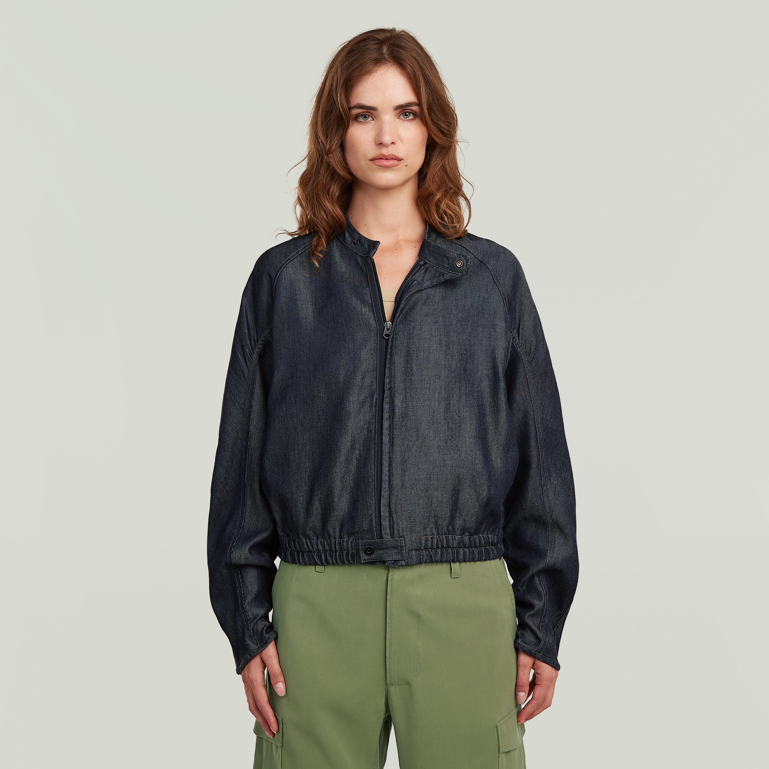 modelo vistiendo una cazadora bomber summer ligera de denim oscuro con cierre de cremallera y cuello alzado