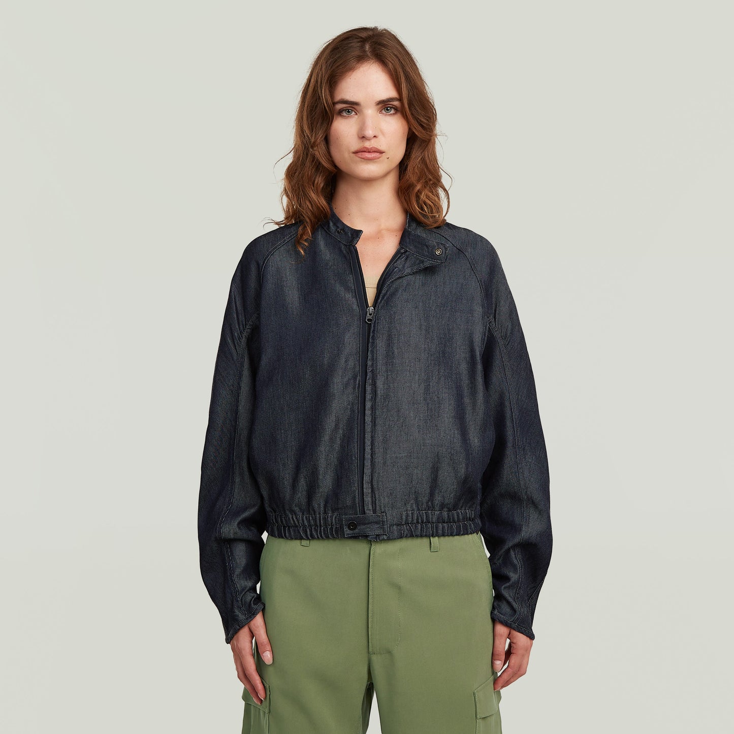 modelo vistiendo una cazadora bomber summer ligera de denim oscuro con cierre de cremallera y cuello alzado