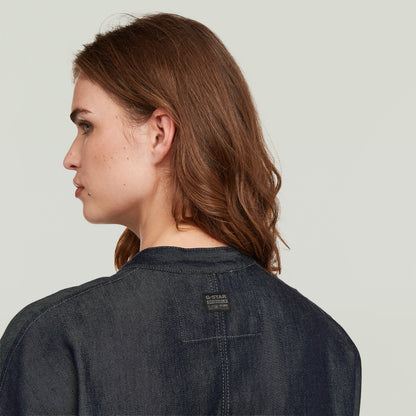 mujer con cazadora bomber summer ligera de denim oscuro, vista trasera mostrando etiqueta G-STAR