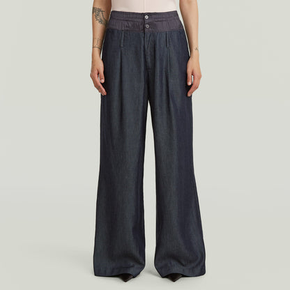 Pantalones Fluid Wide Leg ligeros en denim ligero, corte holgado y talle alto, color azul oscuro.
