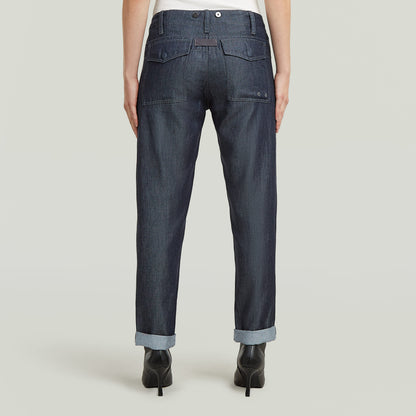 Vista trasera de los pantalones fatigue boyfriend ligeros de denim oscuro con detalles de bolsillos.