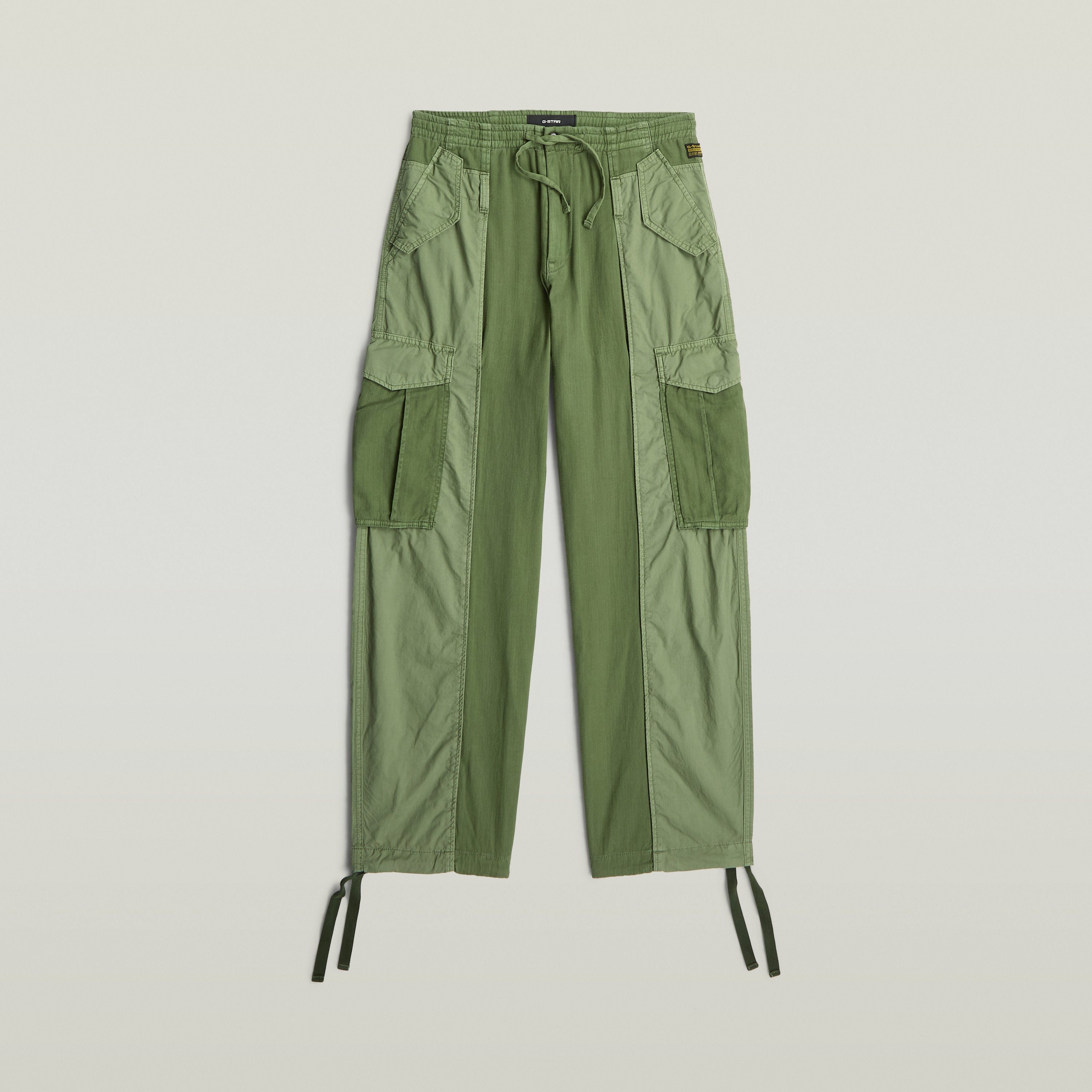 Pantalones Fabric Mix Cargo color verde con múltiples bolsillos, cierre de cremallera, y diseño funcional.