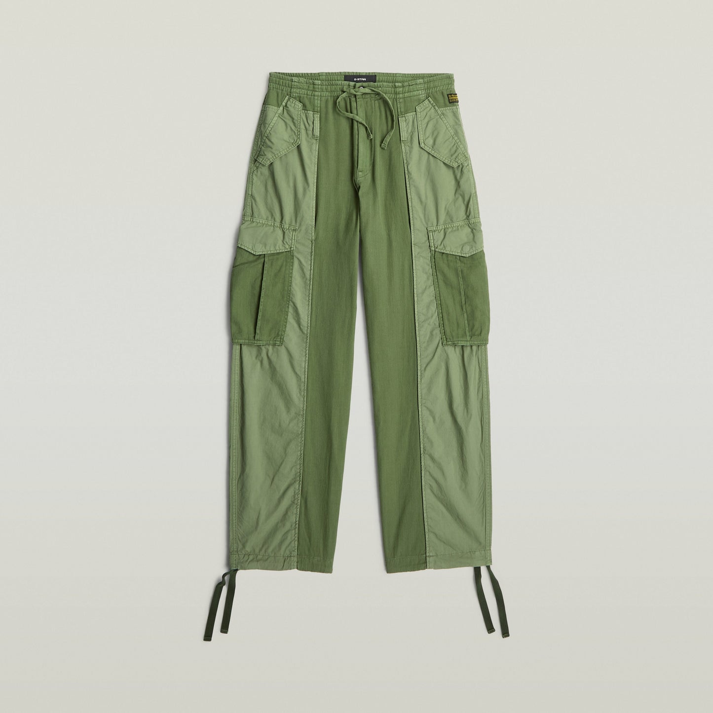Pantalones Fabric Mix Cargo color verde con múltiples bolsillos, cierre de cremallera, y diseño funcional.