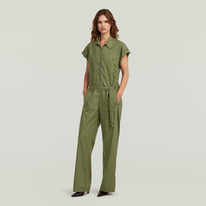 summer jumpsuit with high waist in green with short sleeves and long pants, styled with a belt.