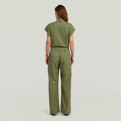 Mujer de espaldas vistiendo un summer jumpsuit with high waist de color verde, con diseño ligero y elegante.