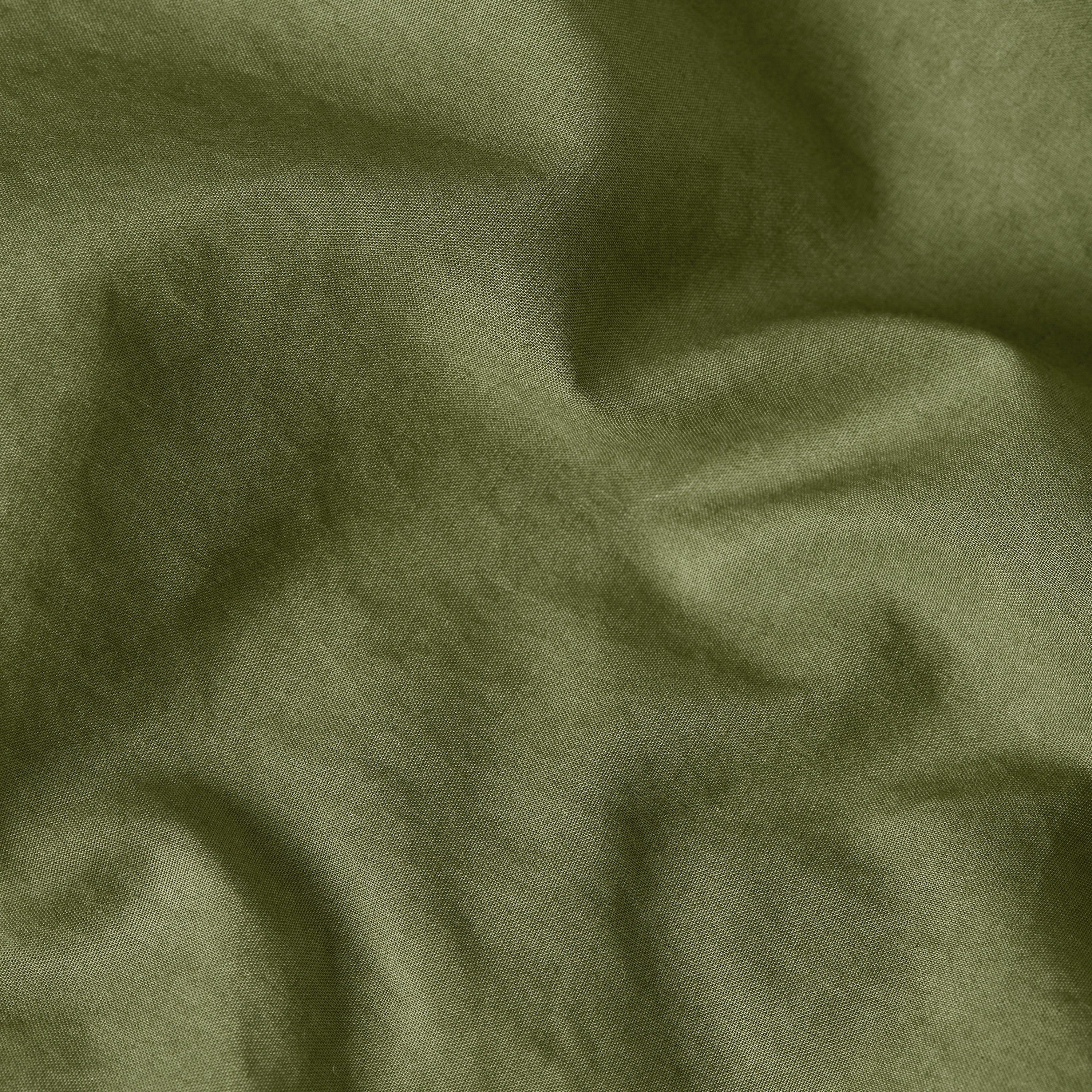 Summer jumpsuit with high waist fabric in a soft green hue, showcasing its lightweight texture.