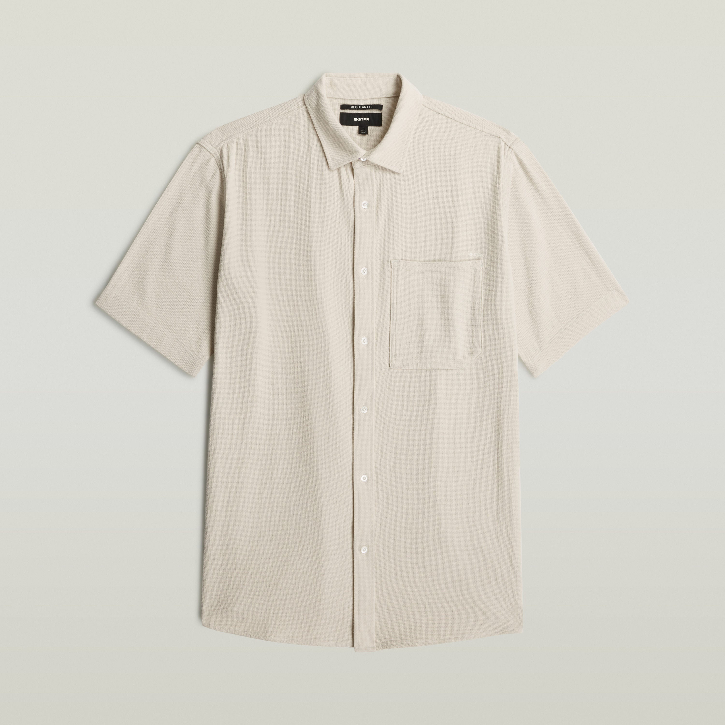 Camisa One Pocket Regular en color blanco con bolsillo en el pecho y cierre de botones, 100 % algodón.