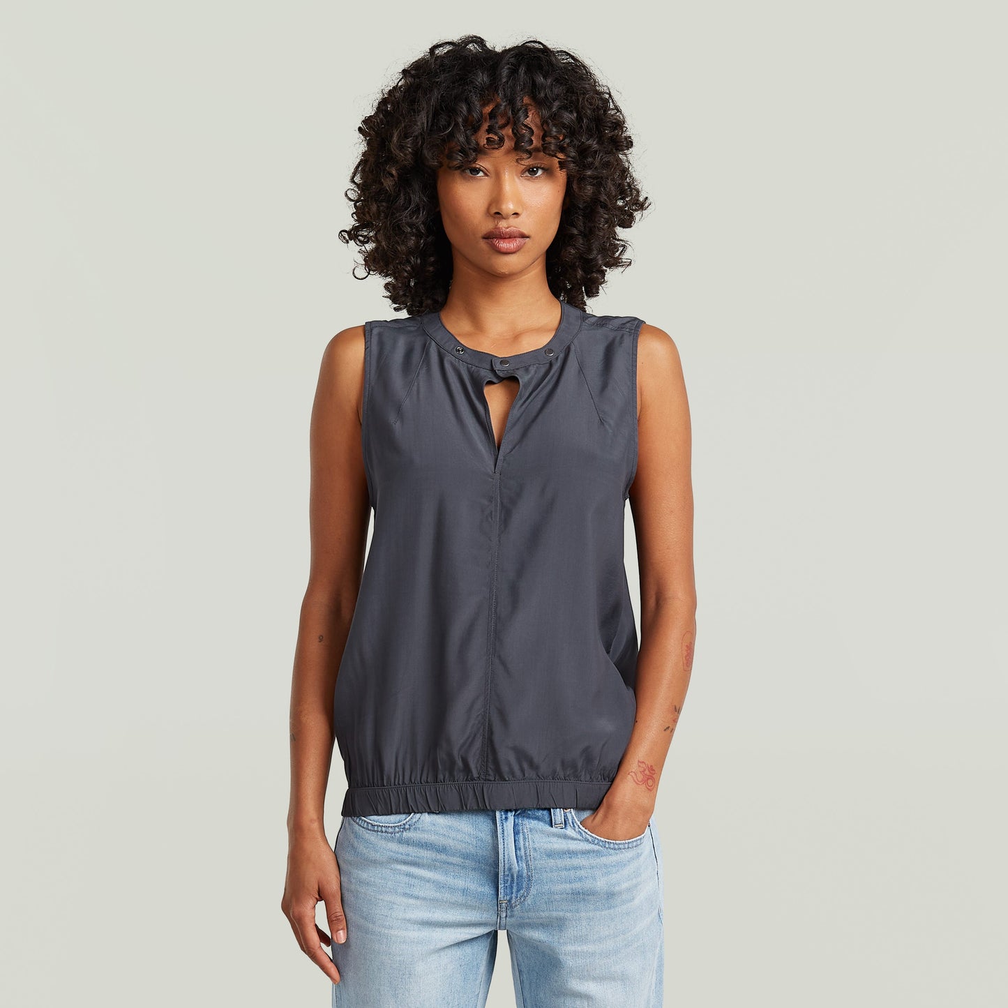 moderna camiseta sin mangas con cuello alzado en gris, con diseño limpio y moderno, ajuste seguro y tejido sostenible.