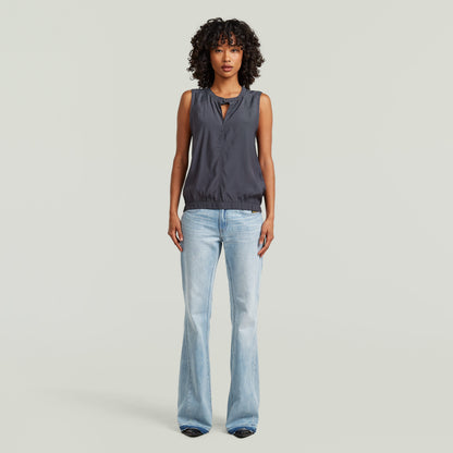 moderna camiseta sin mangas con cuello alzado en color gris, con diseño limpio y moderno.