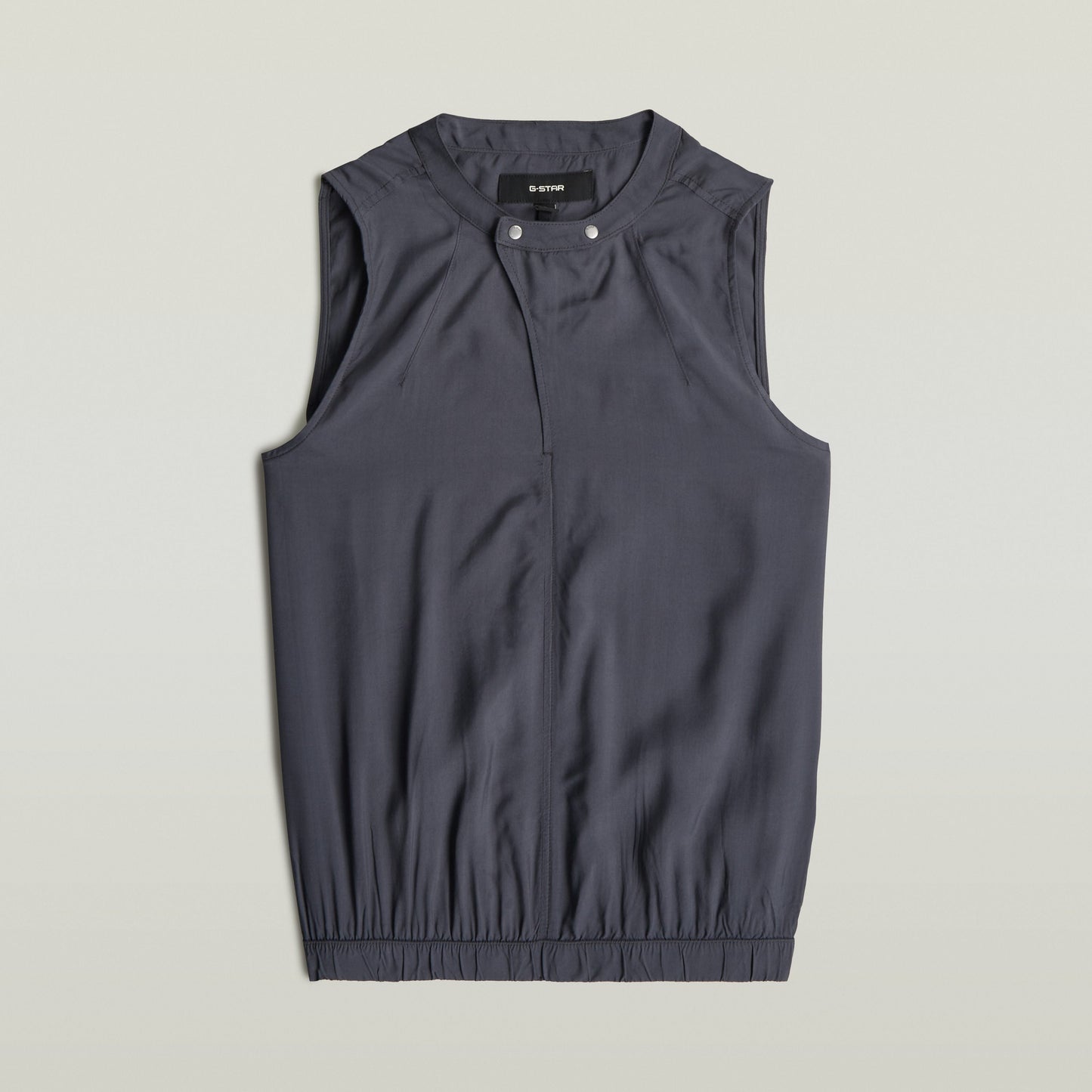 moderna camiseta sin mangas con cuello alzado en color gris con diseño sin mangas y bajo recortado.