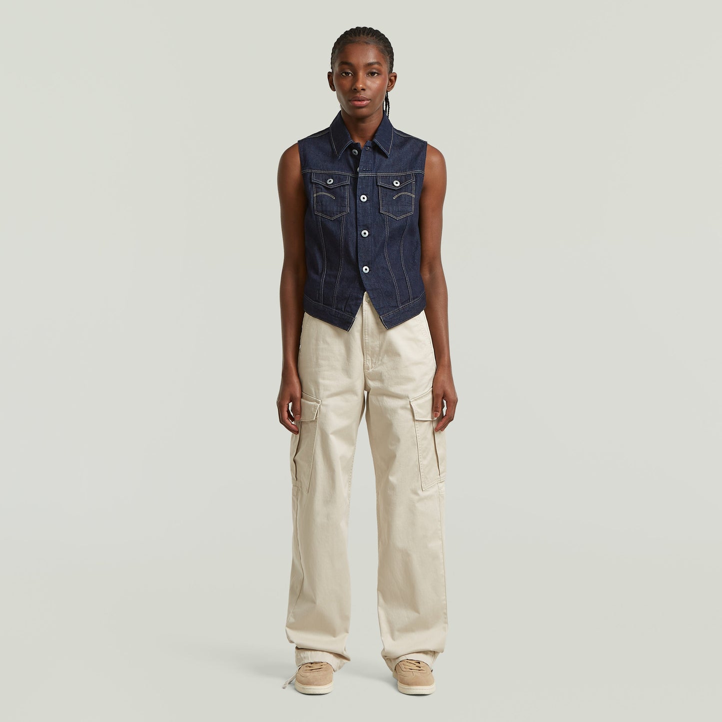 Modelo usando un chaleco Pitched Hem Slim fit denim vest, con botones y cuello de camisa, color azul oscuro.