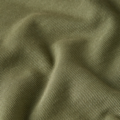 Texture of high-waisted chino fatigue pants in a soft, olive green color.
