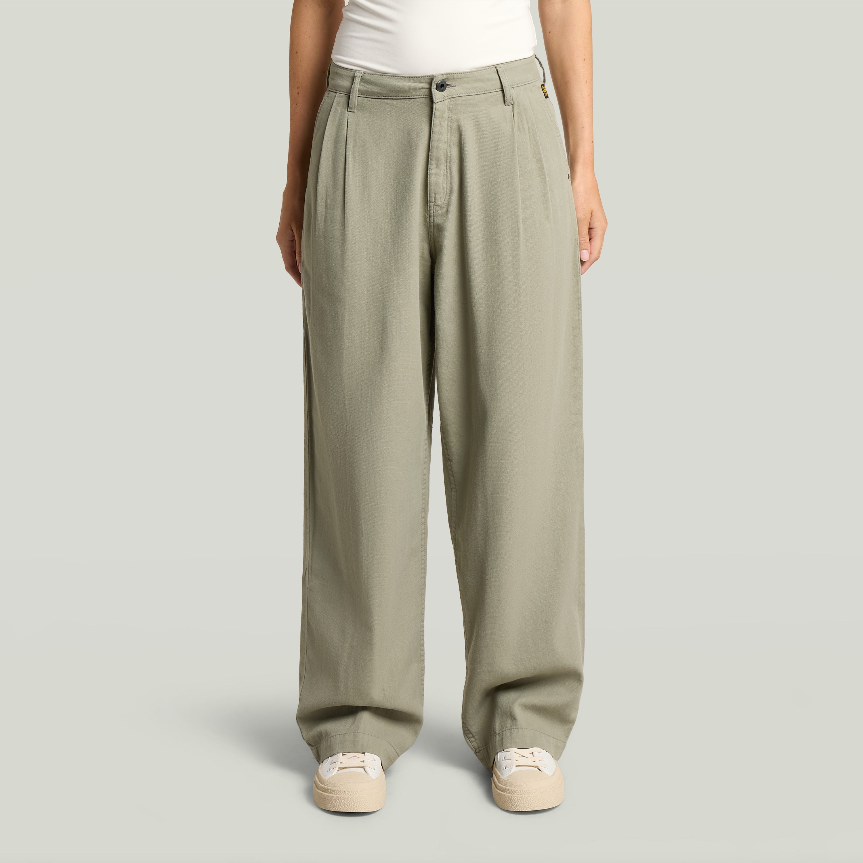 Pantalones pleated chino en color verde con ajuste relajado y diseño plisado, ideales para un estilo atemporal.
