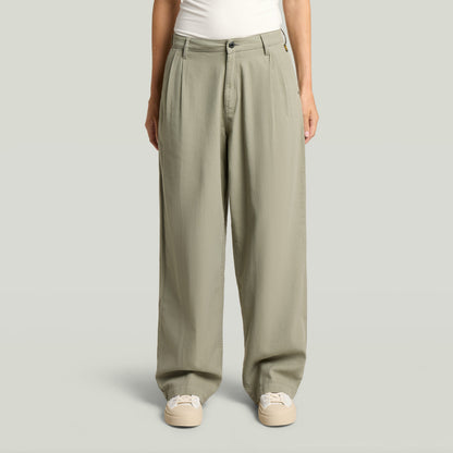 Pantalones pleated chino en color verde con ajuste relajado y diseño plisado, ideales para un estilo atemporal.