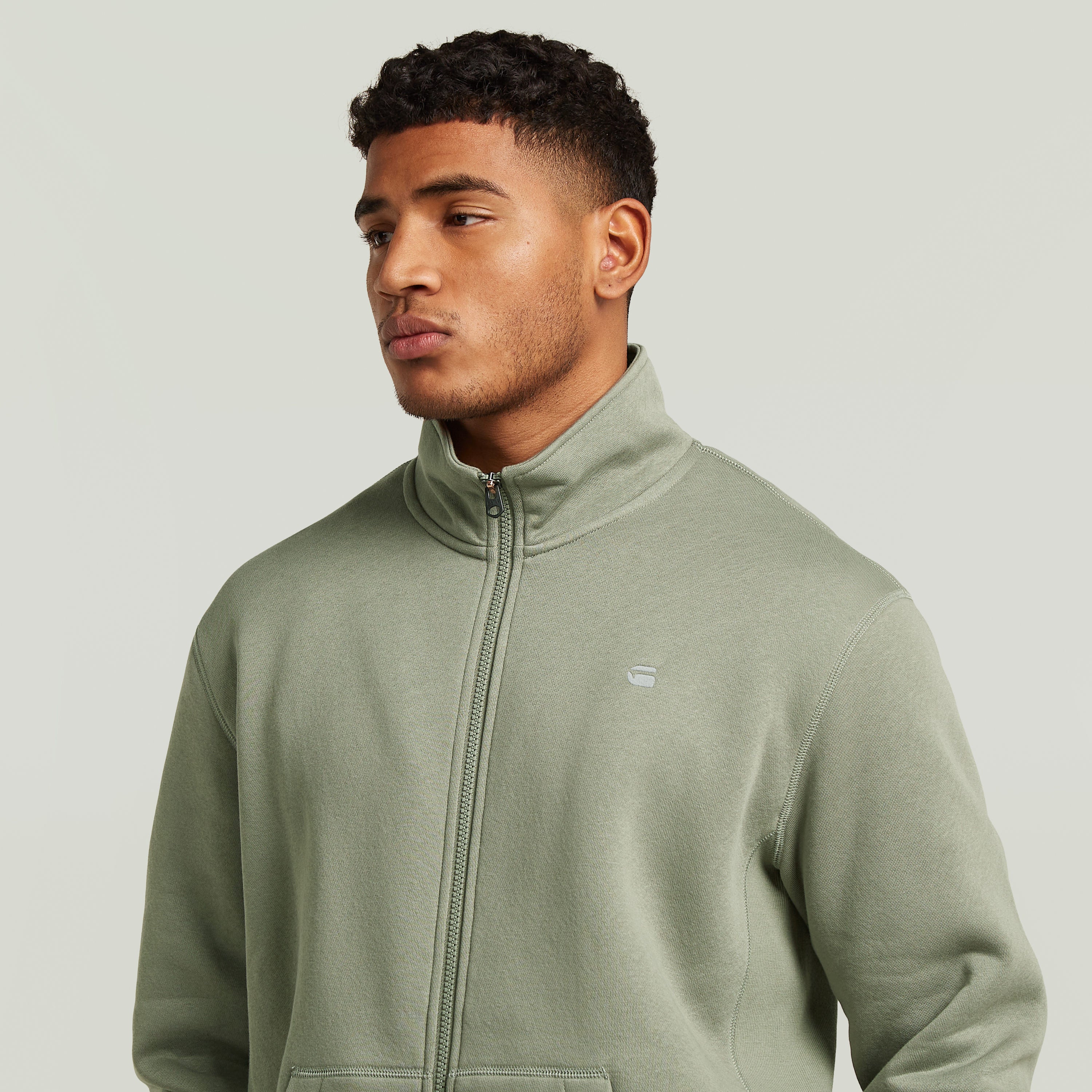 Chaqueta deportiva Premium Core Track en color verde, con cuello alzado y diseño elegante.