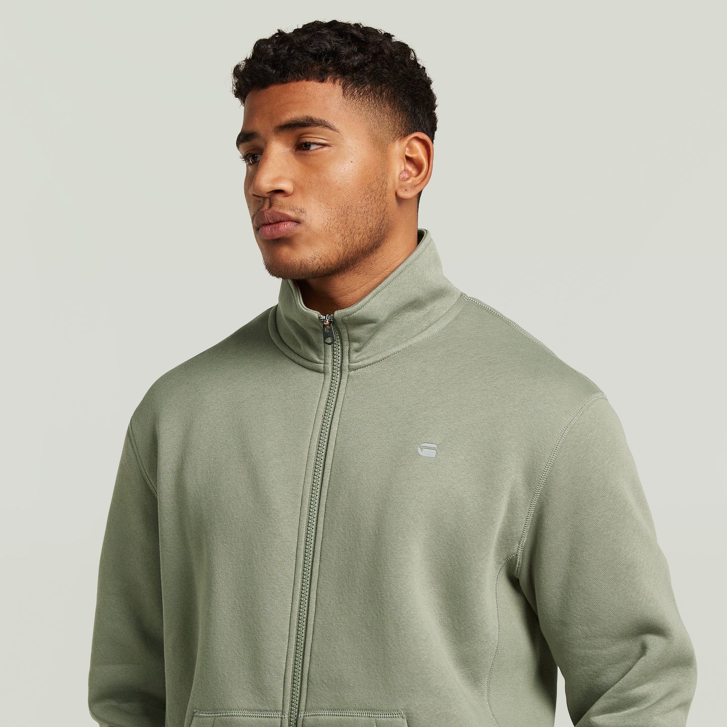 Chaqueta deportiva Premium Core Track en color verde, con cuello alzado y diseño elegante.