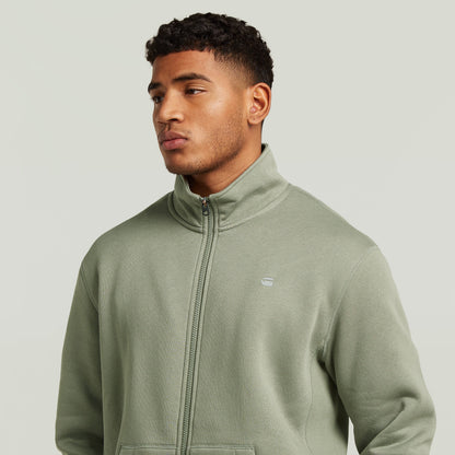 Chaqueta deportiva Premium Core Track en color verde, con cuello alzado y diseño elegante.