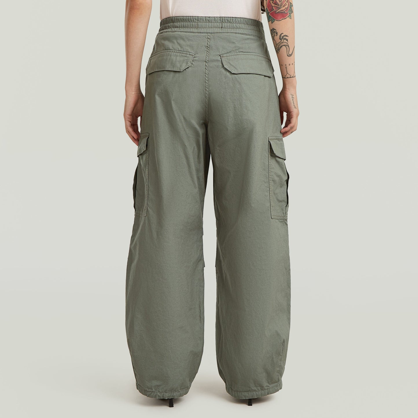 Vista trasera de pantalones wide leg cargo en color verde, con bolsillos laterales y cintura alta.