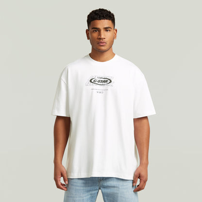Hombre usando una camiseta blanca, camiseta gráfica relajada, estilo moderno y corte suelto.