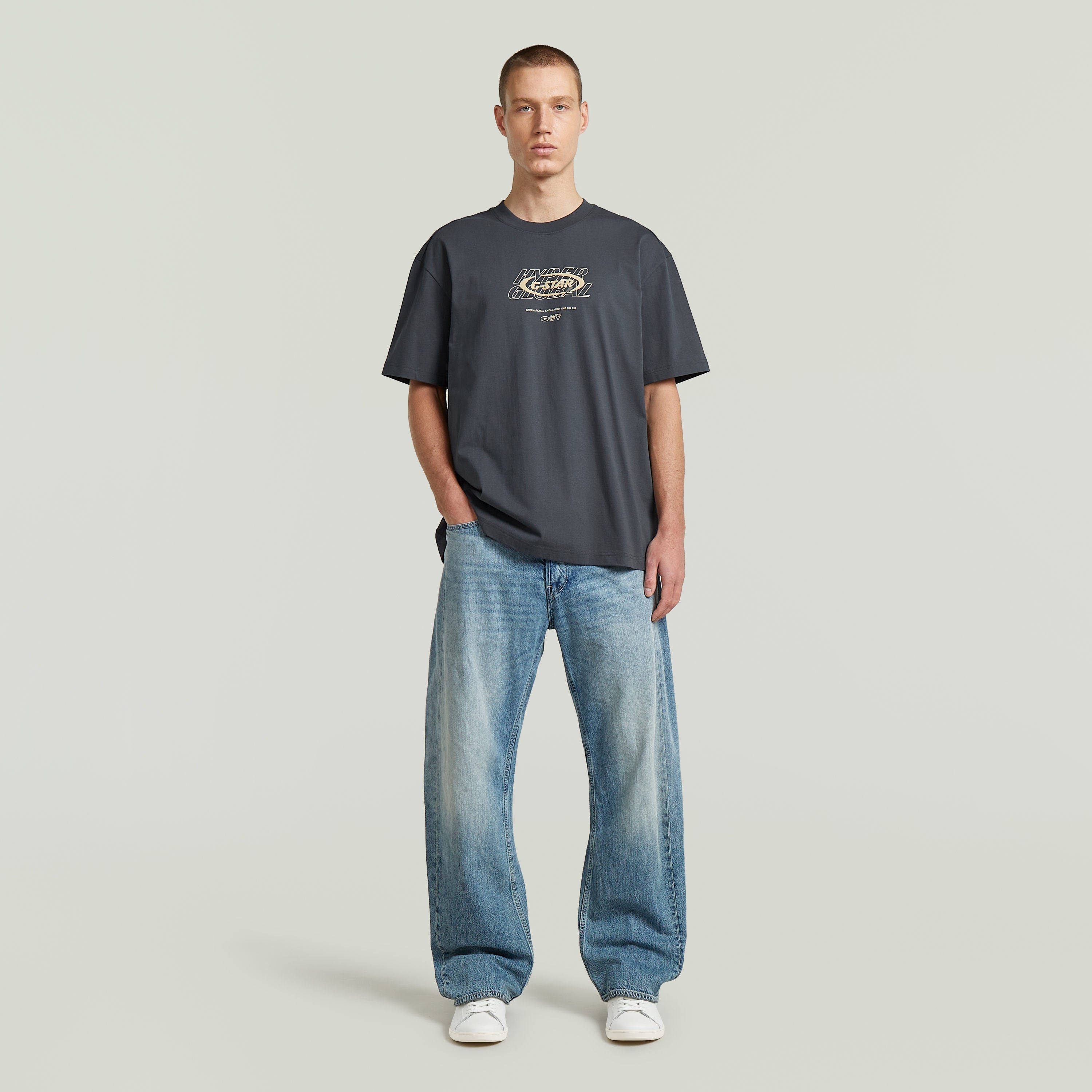 Modelo con camiseta Hyper Graphic Relaxed, una relaxed fit graphic t-shirt de color gris y cortes relajados.