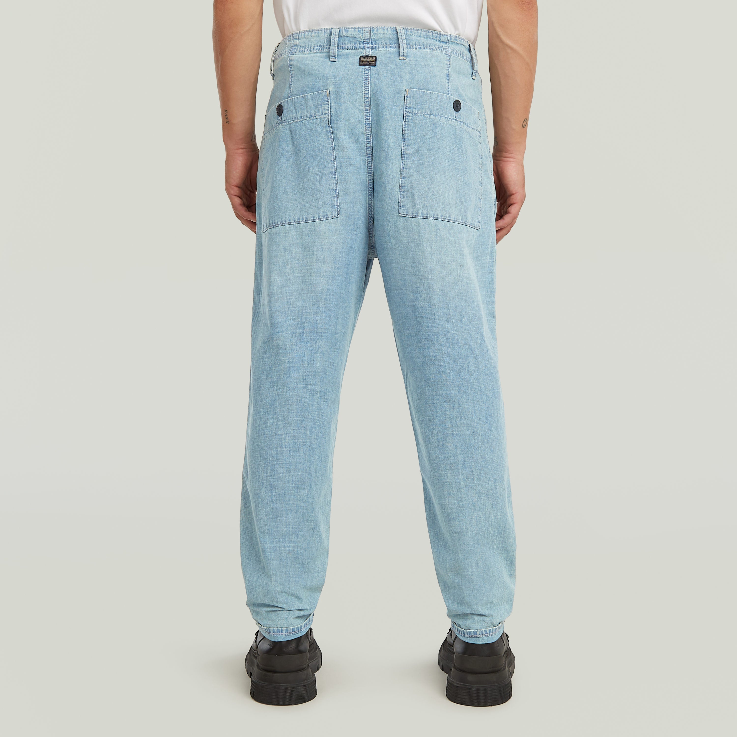Denim relaxed tapered chinos showing back view with patch pockets and tailored fit.