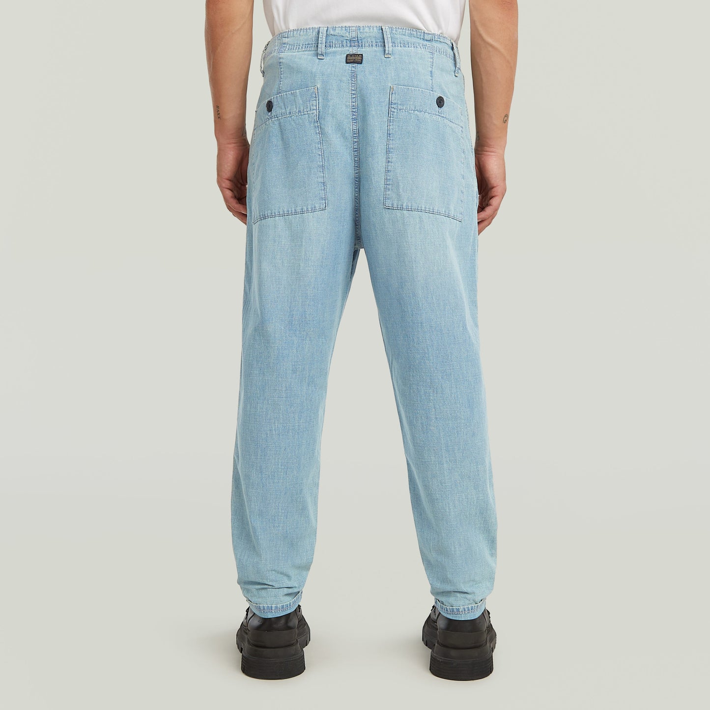 Denim relaxed tapered chinos showing back view with patch pockets and tailored fit.