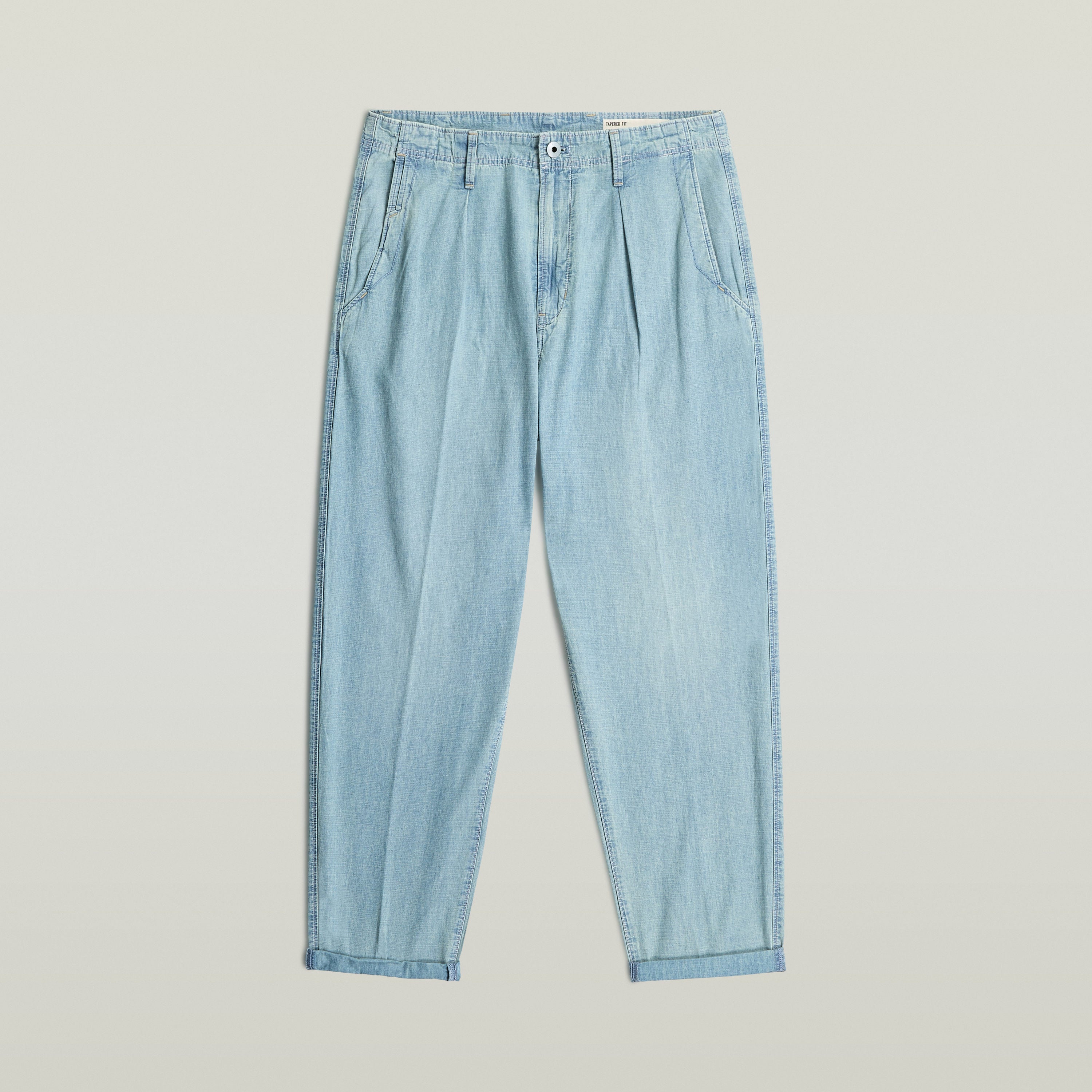 Chino plisado en denim Relaxed Tapered, diseño moderno y funcional en color claro, 100% algodón.