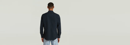 Hombre de espaldas vistiendo la Camisa Dakota Slim en color oscuro, mostrando su corte moderno y elegante.