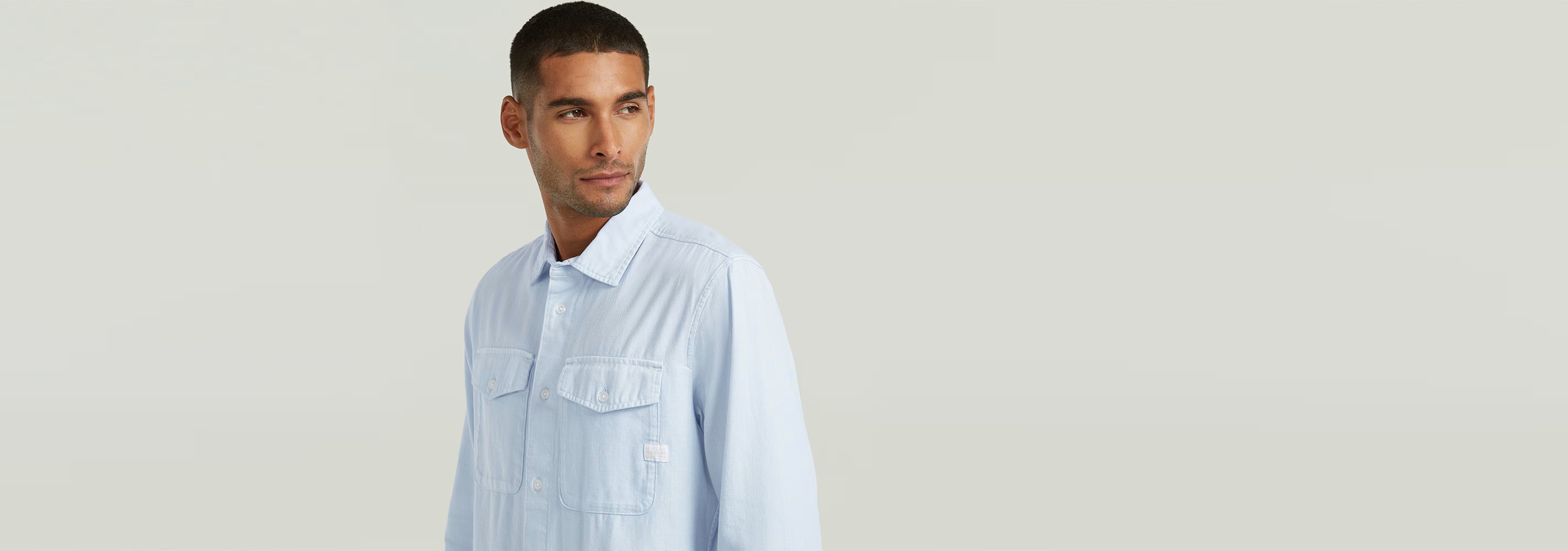 Hombre modelando la Camisa Marine Slim de corte ajustado y bajos redondeados, con bolsillos en el pecho.